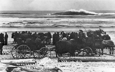 The scene on the beach after the Mimi capsized dramatically with heavy loss of life as a result of an irresponsible and reckless salvage attempt. A wave breaks over the almost-submerged hull of the Mimi. Inside that hull are the bodies of drowned German sailors, trapped inside when the vessel capsized.